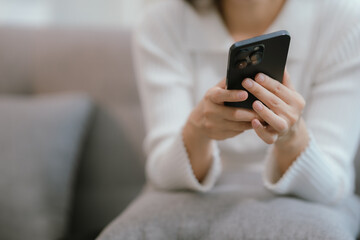 Close-up of a young woman's hand holding a smartphone and chatting on social media.