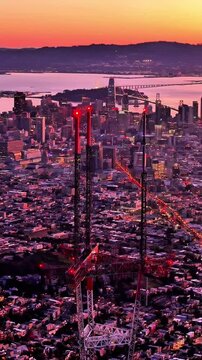 Sutro Tower with San Francisco skyline and the ocean in the soft warm glow of sunset in California