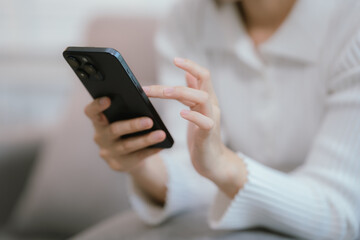 Close-up of a young woman's hand holding a smartphone and chatting on social media.
