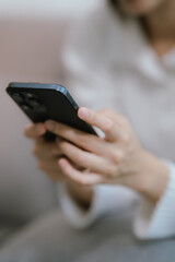 Close-up of a young woman's hand holding a smartphone and chatting on social media.