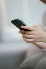 Close-up of a young woman's hand holding a smartphone and chatting on social media.