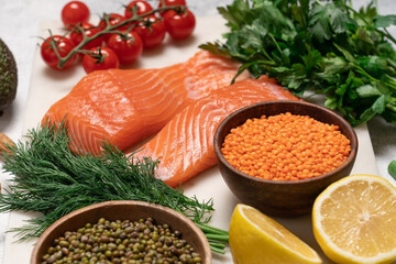 Healthy food set on marble board and white background. Salmon fillet, avocado, almonds, mung beans,...