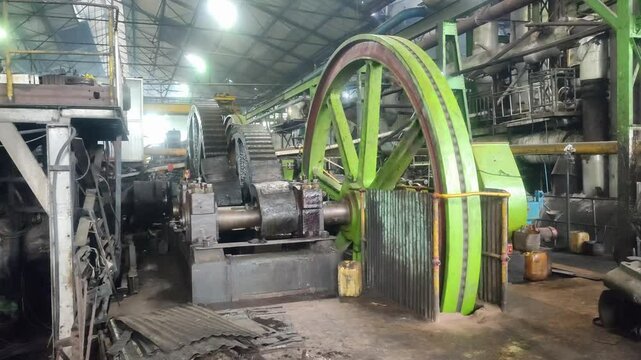 Steam engine flywheel and transmission spinning in motion, showcasing vintage mechanical power and industrial energy in action.