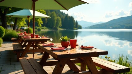 Obraz premium Scenic lakeside picnic area with wooden tables and green umbrellas.