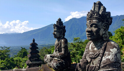 Obraz premium Serene Balinese stone statues overlooking lush mountain view create tranquil atmosphere, inviting reflection and peace. intricate details of statues enhance natural beauty surrounding them