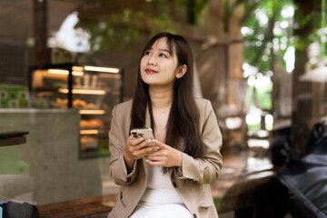 Portrait of young woman in a cafe using phone