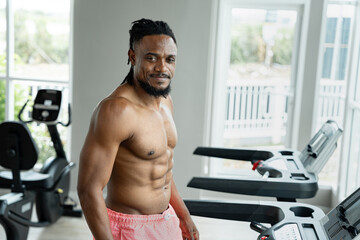 Healthy African man Running on Treadmill at fitness gym	