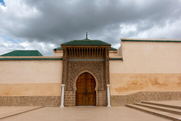Elegant Moroccan arches and ornate doors grace the vibrant Meknes medina showcasing intricate...
