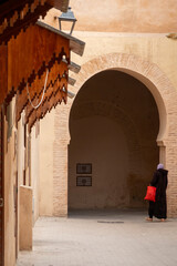 Elegant Moroccan arches and ornate doors grace the vibrant Meknes medina showcasing intricate...