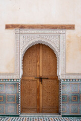 Elegant Moroccan arches and ornate doors grace the vibrant Meknes medina showcasing intricate...