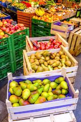 Fresh fruits displayed in vibrant crates at a bustling market offering a variety of seasonal produce in the heart of the city