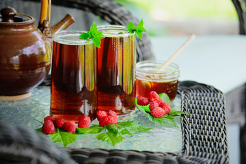 Herbal tea with raspberries and mint leaves in tall glasses