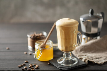 Honey Dalgona Coffee. Whipped instant vegan coffee in a glass with beans . Concept of a trendy and popular drink.