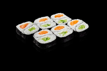 Delicious hosomaki sushi rolls with salmon and avocado filling on black background