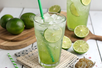 Fototapeta premium A refreshing green limeade is served in a glass with a green straw white background Ai generate.