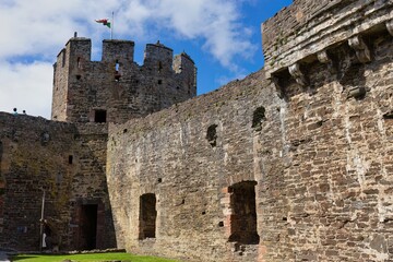 A weathered stone castle's interior walls and towers stand under a bright sky. Conwy Castle - Conwy - Wales - Great Britain

