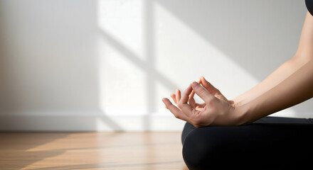 Close-up of a hand in a meditative gesture, resting on a yoga mat, with soft sunlight casting gentle shadows on the wooden floor, creating a serene atmosphere for mindfulness practice