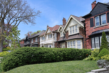Suburban street with row of traditional detached two story houses