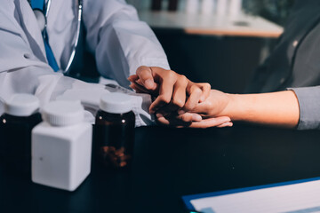 female doctor or woman medical staff holding hand, working hand in hand, giving encouragement to patient or relative of patient; concept of woman health care worker, doctor, therapist, medical worker