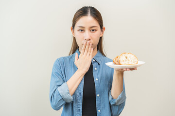 Gluten allergy, asian young woman hand covering mouth refusing to eat bread slice loaf on plate in...