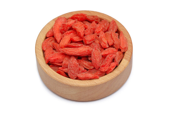 Goji berries in a wooden plate, insulation on a white background