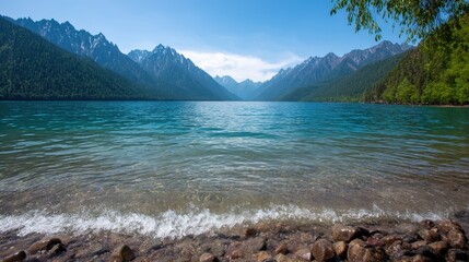 Scenic Turquoise Lake Surrounded by Green Forested Mountains With Clear Blue Sky