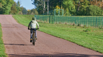 junger sportlicher Fahrradfahrer auf einem Weg im Herrenkrugpark in Magdeburg