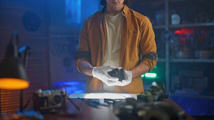 Man Examining Vintage Camera with Precise Care