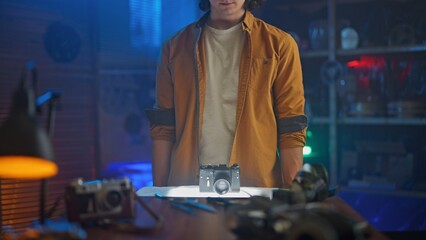 Person Inspecting Vintage Camera on Desk with Gloves