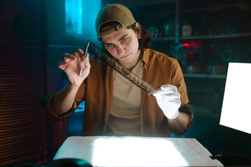 Young Person Analyzing Film in Dimly Lit Room