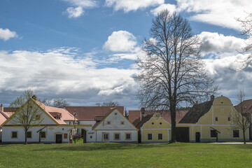 Häuserreihe mit Baum in Hollschowitz, Tschechien