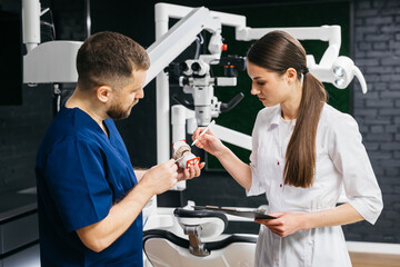 In a modern dental clinic, dentists discuss treatment details by analyzing the diagnosis on a jaw...