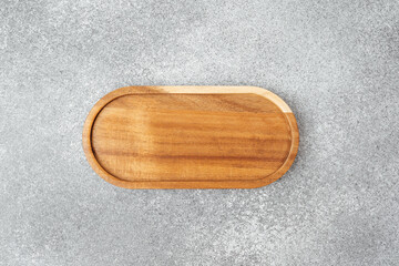 Wooden serving tray placed on a gray surface with a minimalist design