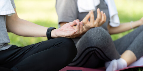 Wellness yoga session for seniors: couple meditating outdoors