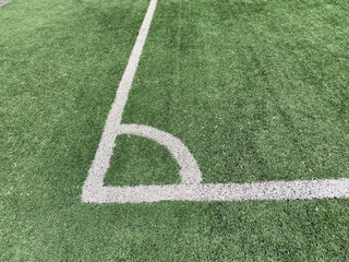 Corner kick spot or corner area. Artificial turf on a football field with a fragment of white...