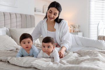 Fototapeta premium Bedtime. Mother with her cute little babies on bed at home