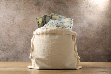 Bag with dollar banknotes on wooden table