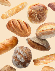 Different types of bread falling on beige background