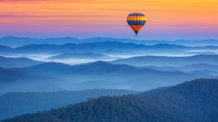 Fototapeta premium Yellow hot air balloon gliding over vibrant autumn mountains during a beautiful sunrise
