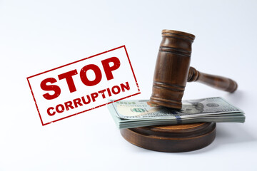 Stop corruption. Law gavel with stack of dollars on white background