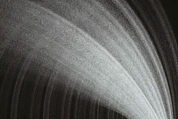 Abstract cosmic waterfall with subtle gray sparkles gracefully cascading against a stark black backdrop