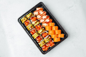 Sushi platter with assorted rolls and nigiri displayed on a black tray