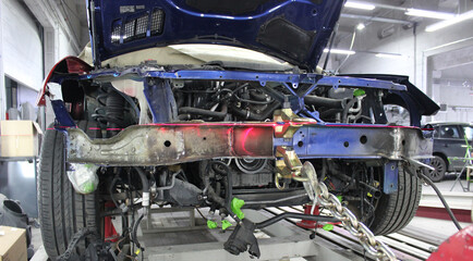 Frame and Parts of Disassembled Front End of Car on Auto Slipway for Chassis Repair. Damaged Car on...