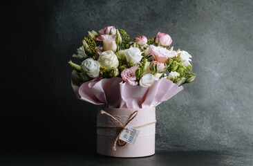 Beautiful floral arrangement in a soft pink vase on a dark background