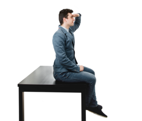 Full length portrait of businessman sitting on the office desk looking far away with hand to forehead isolated on transparent background