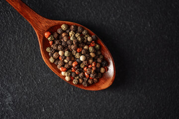 Warm spices on a wooden spoon against a dark background showcasing flavors