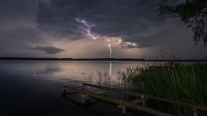 Fotobehang Pier Lightning storm over lake and wooden pier in Masuria, Poland.  © Tomasz Wozniak