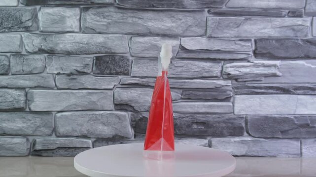 Red drink in doypack plastic bag. Convenient reusable container for alcoholic and non-alcoholic beverages on walks and events instead of breaking and dangerous glass bottles.