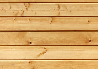 Fototapeta premium A wooden wall with a grainy texture and a light brown color