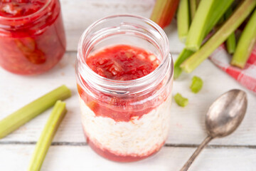 Sweet rhubarb overnight oats in portioned jar. Summer tasty healthy vegan food. Dietary breakfast...